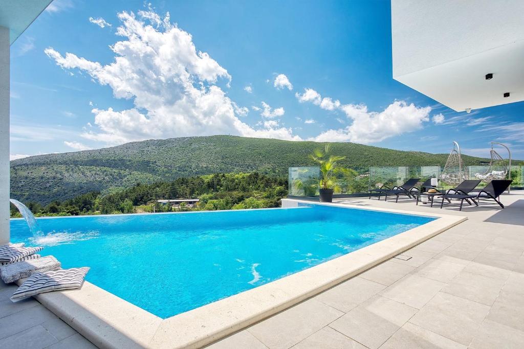Bazén v ubytovaní NEW! Villa Top Hill, heated infinity pool, Jacuzzi, Sauna, 5 en-suite bedrooms, a Media room alebo v jeho blízkosti