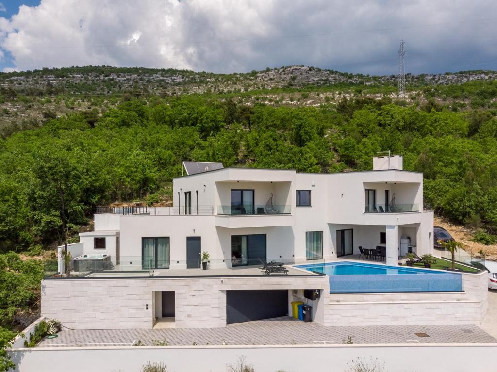 Bazén v ubytovaní NEW! Villa Top Hill, heated infinity pool, Jacuzzi, Sauna, 5 en-suite bedrooms, a Media room alebo v jeho blízkosti