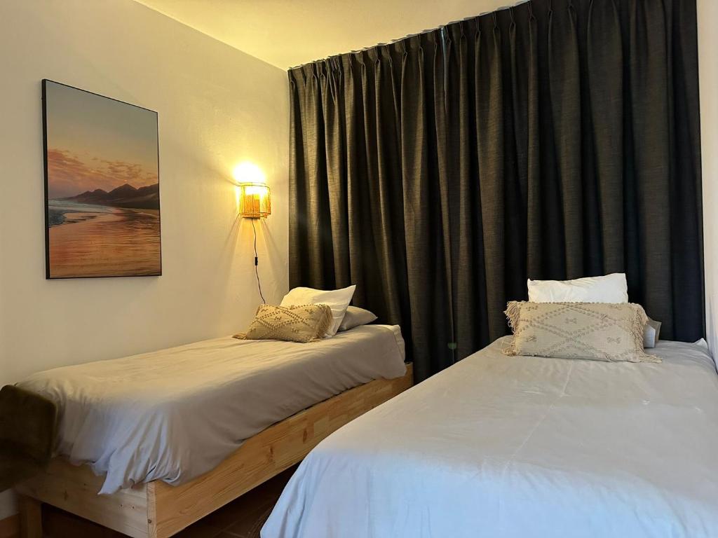 twee bedden in een hotelkamer met een raam bij Villa Casa Senna in Corralejo