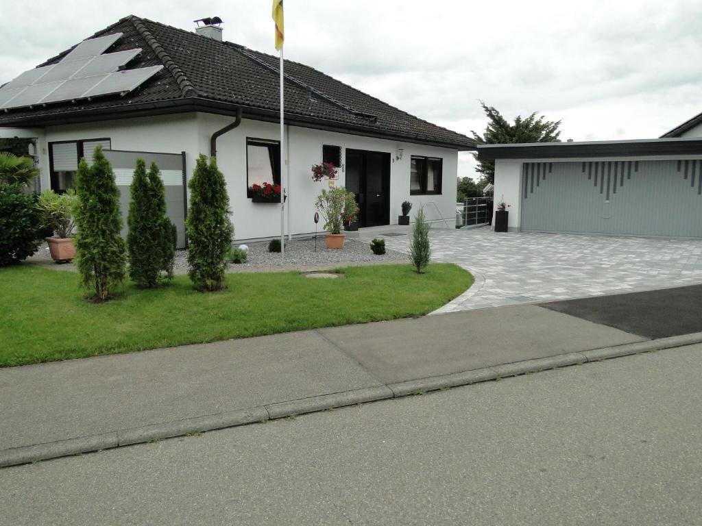 a white house with a flag in the yard at 3 Sterne Gästehaus Zollerblick in Zimmern
