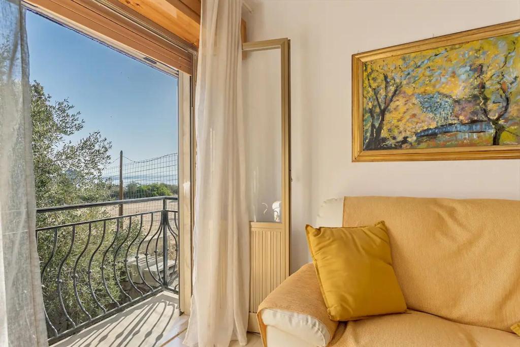 a living room with a couch and a large window at Casa Marea in Marina di Gairo