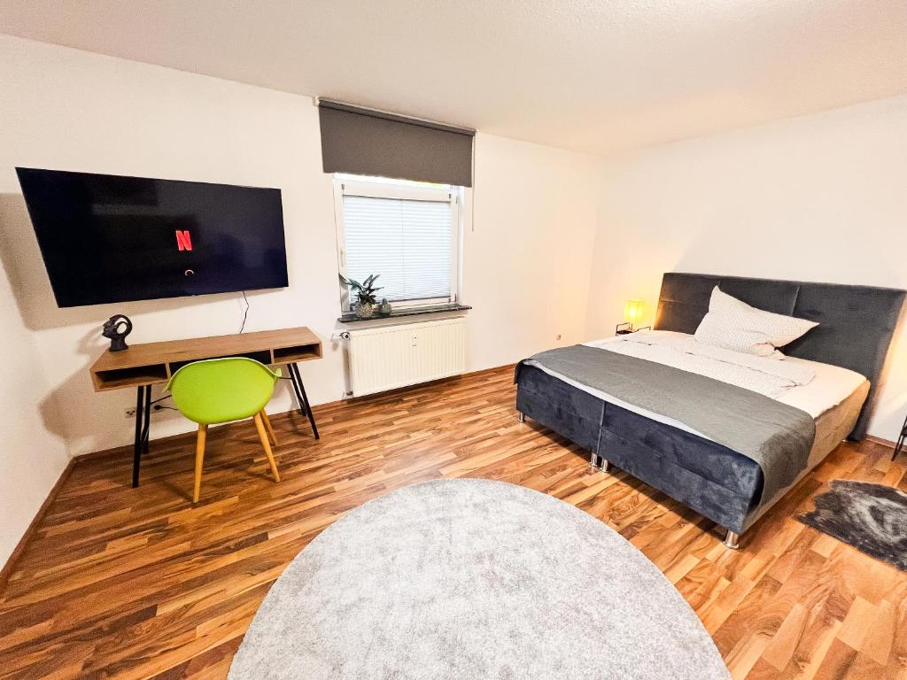 a bedroom with a bed and a desk and a television at Qonroom - as individual as you - Wulferdingsen in Bad Oeynhausen