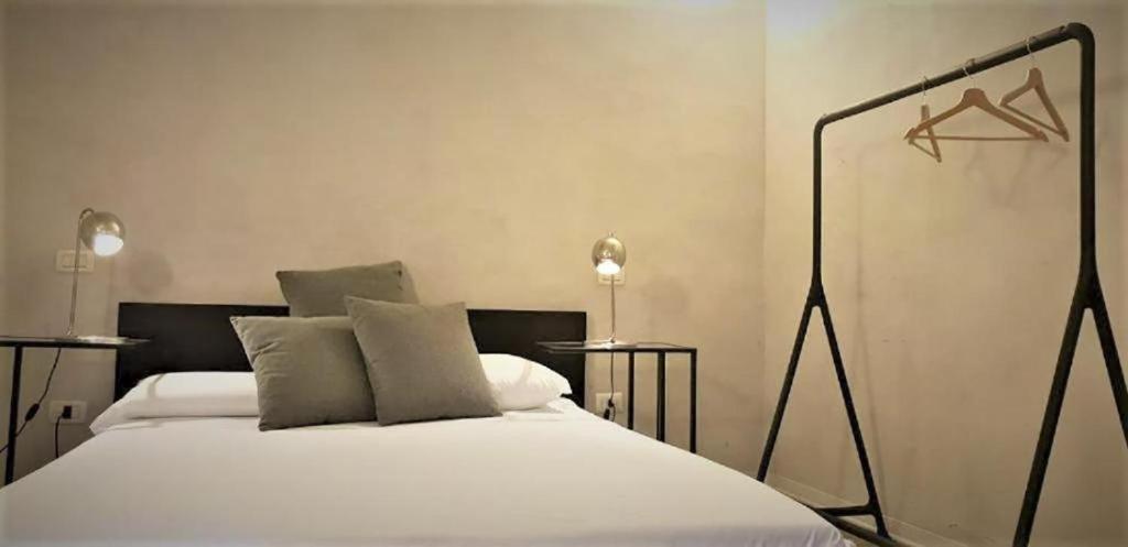 um quarto com uma cama com lençóis brancos e 2 candeeiros em Casa Milano - Apartments and Rooms - Duomo's Whisper em Milão