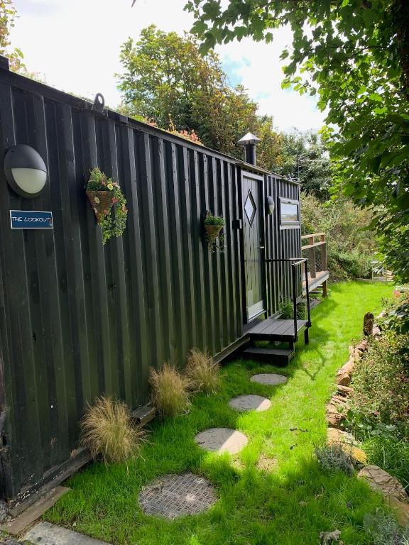 a black fence with a bench next to a yard at The Lookout in Padstow