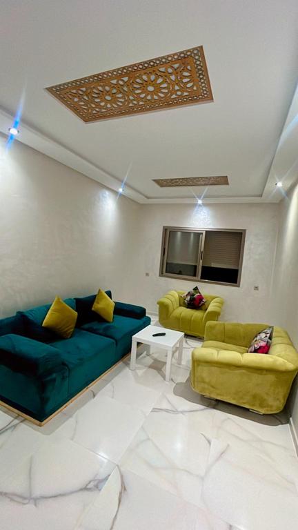 a living room with two couches and a table at Très belle appartement à louer sur bouznika de 117 m2 avec ascenseur in Bouznika