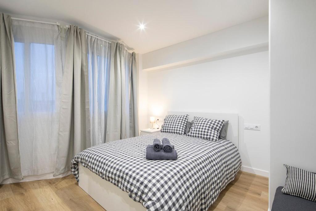 a bedroom with a bed with a black and white checkered blanket at Garo in Vigo