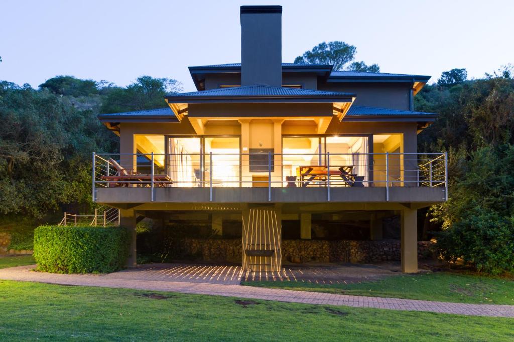 ein Haus mit einer großen Terrasse mit Kamin in der Unterkunft Stonehill River Lodge by Dream Resorts in Buffeljagsrivier