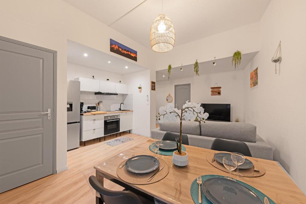 Il comprend un salon et une cuisine avec une table et des chaises. dans l'établissement Spacieux T2 au centre ville avec parking et climatisation, à Carcassonne