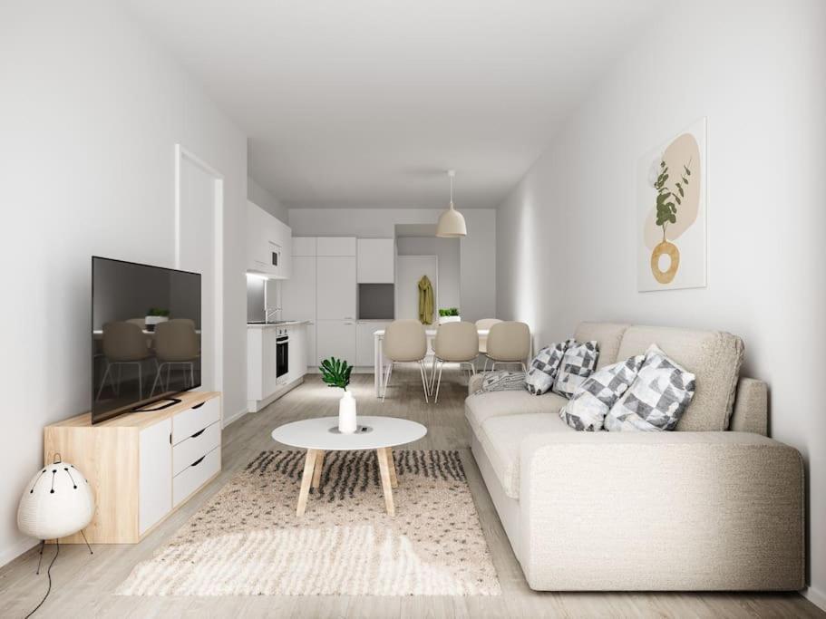 a white living room with a couch and a table at Compact 2BDR Apartment with Private Sauna in Rovaniemi