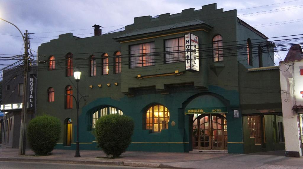 a green building on the corner of a street at Hotel Cordillera in Talca