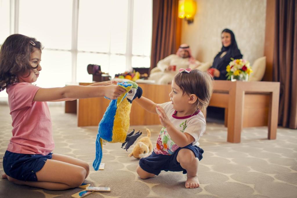 two little girls playing with a toy in a room at Yas Island Rotana Abu Dhabi in Abu Dhabi