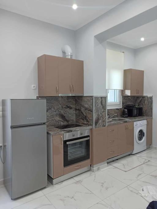 a large kitchen with wooden cabinets and appliances at Chios Cozy Apartment 3 in Sklaviá