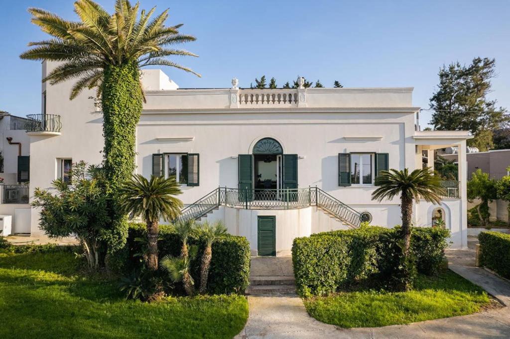 a white house with palm trees in front of it at 4 Bedroom Villa, Private Pool, Marsala in Marsala