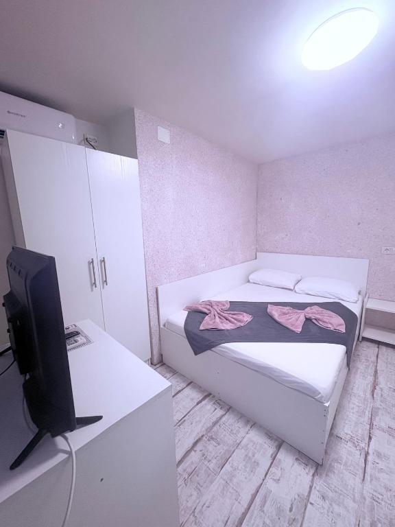 una piccola stanza con due letti e una televisione di Klara central a Constanţa