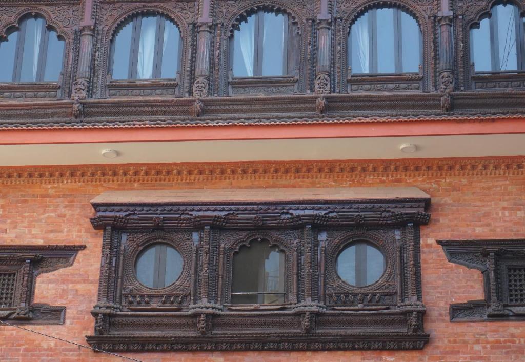 an ornate window on the side of a brick building at Kathmandu home in Kathmandu