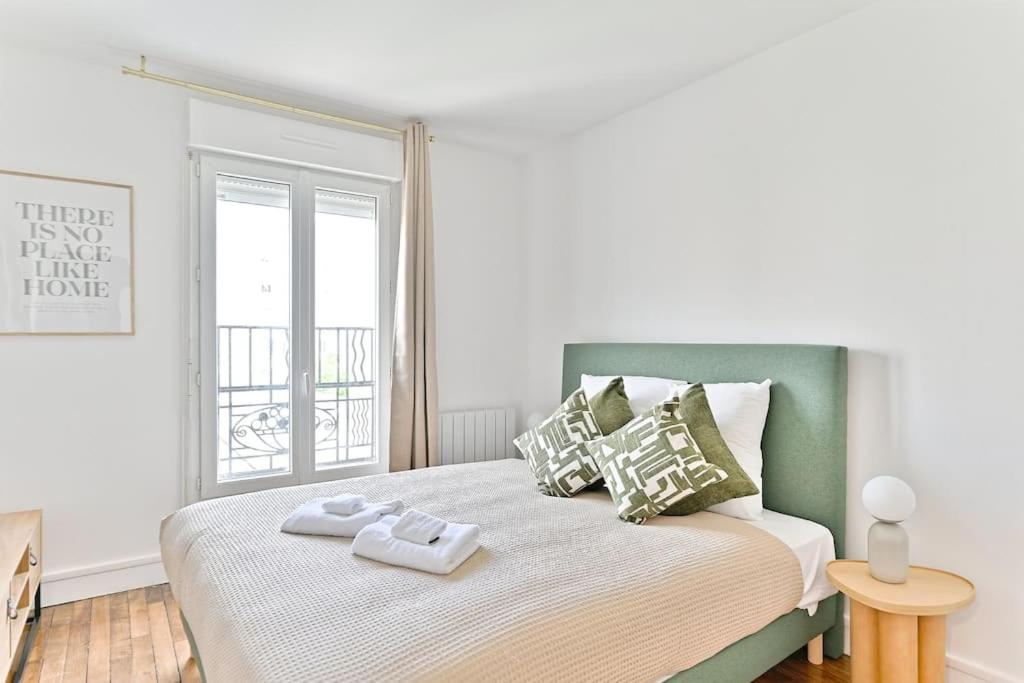 une chambre avec un grand lit avec deux serviettes dessus dans l'établissement Agréable studio dans la paisbile de Montreuil-II, à Montreuil