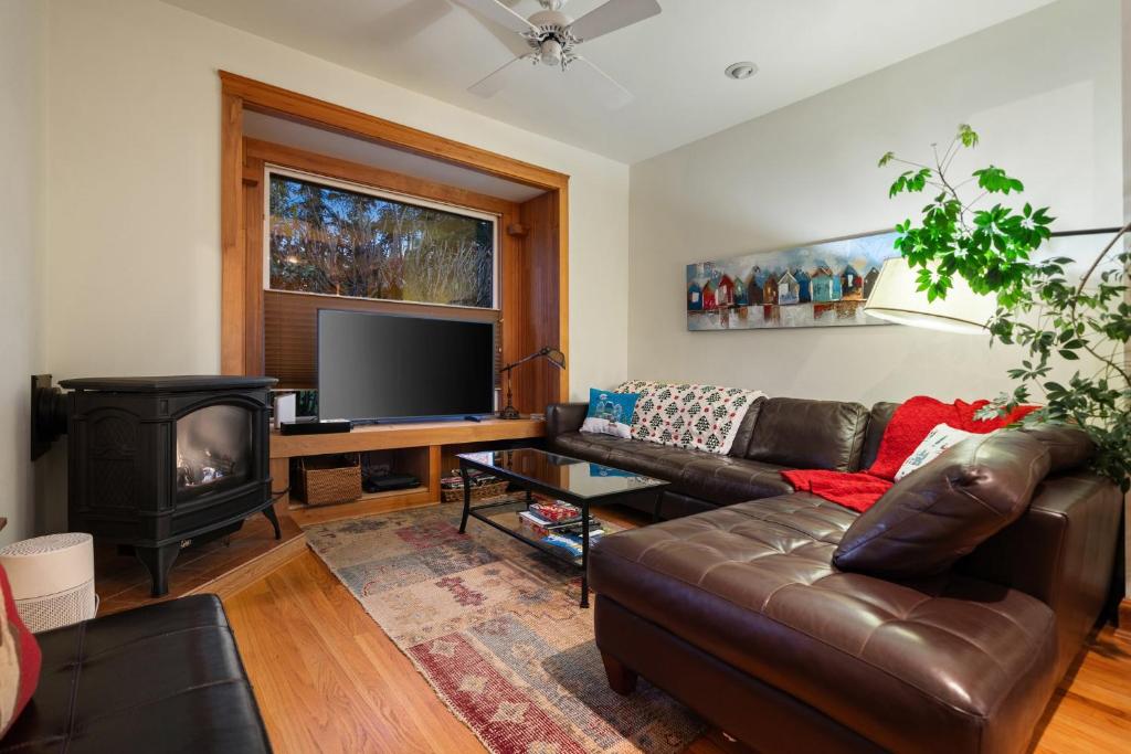 a living room with a leather couch and a television at Geneva Retreat in Bellingham