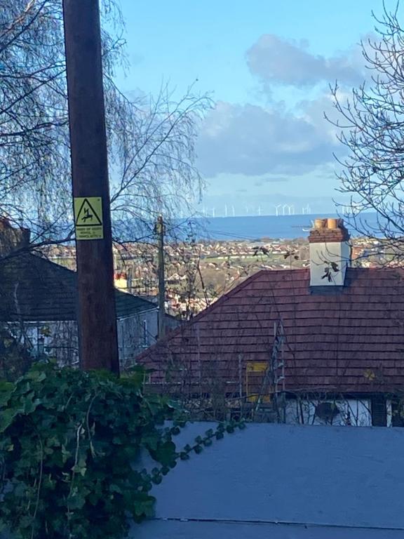 a pole with a sign on it next to a house at Bright cozy rooms in Meliden in Meliden