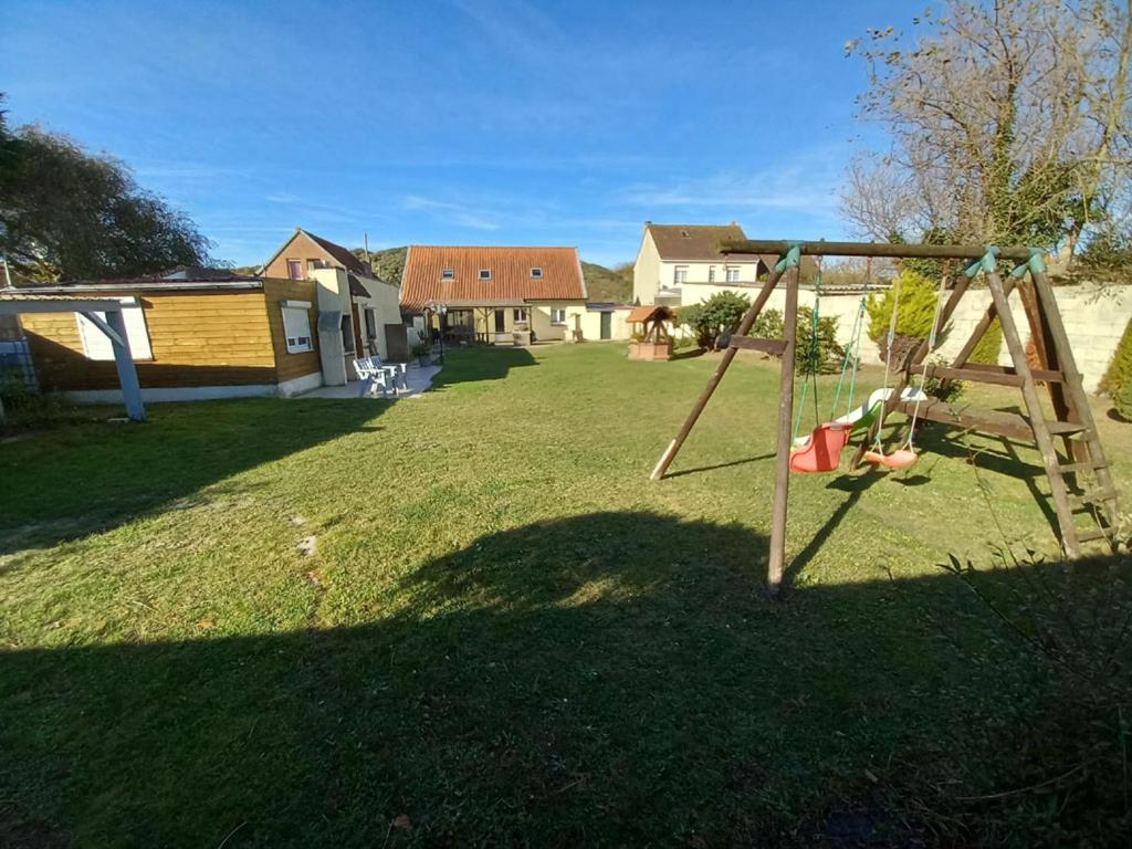 une balançoire dans une cour avec des maisons en arrière-plan dans l'établissement La Dune, à Berck-sur-Mer