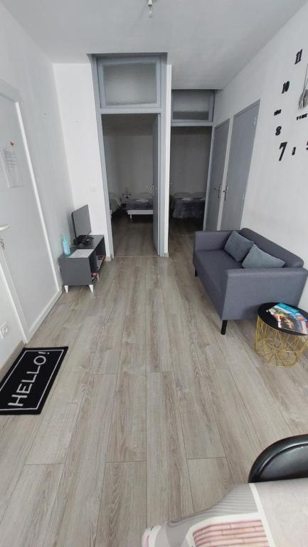 un soggiorno con divano blu e pavimento in legno di Chez Marie appartement centre historique Perpignan a Perpignano
