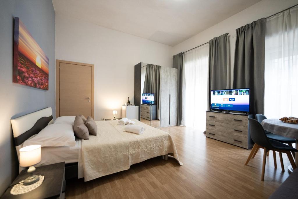 sypialnia z łóżkiem i telewizorem z płaskim ekranem w obiekcie home Joséphine, a due passi dalla Reggia w mieście Caserta