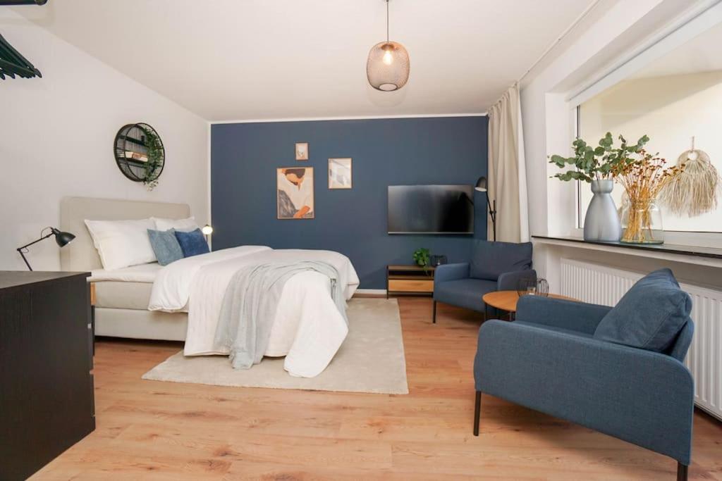 a bedroom with a bed and a blue wall at Citycenter Living 1Zi HP 2P Mitte in Bremerhaven