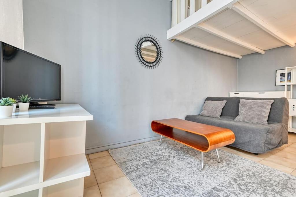 un salon avec un canapé et une télévision dans l'établissement Le Marseillais - Vieux Port, à Marseille