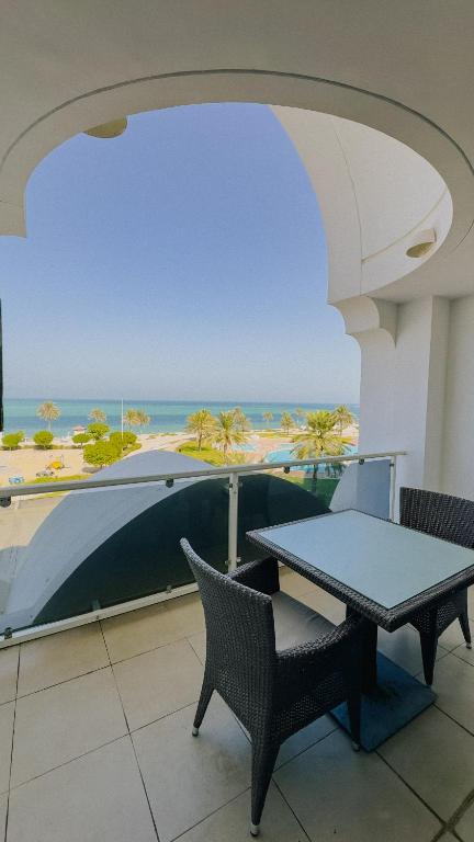 a balcony with a table and a view of the beach at Mirfa Hotel in Al Mirfa