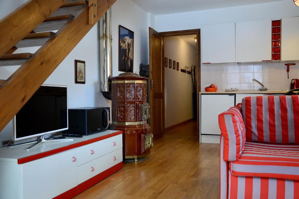 un salon avec une télévision et une cuisine dans l'établissement Hostdomus - Casa Borgata, à Borgata Sestriere