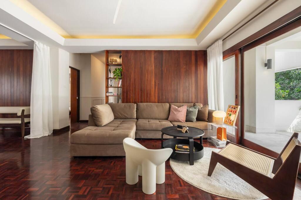 een woonkamer met een bank en een tafel bij Timber & Terrace in Bangkok