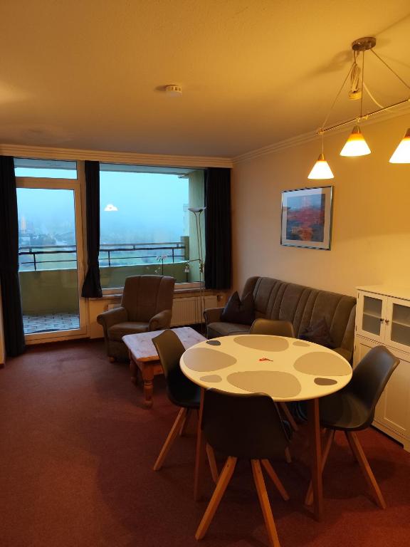 a living room with a table and chairs and a couch at Apartment Morgengruß - Pool & Sauna in Hohegeiß