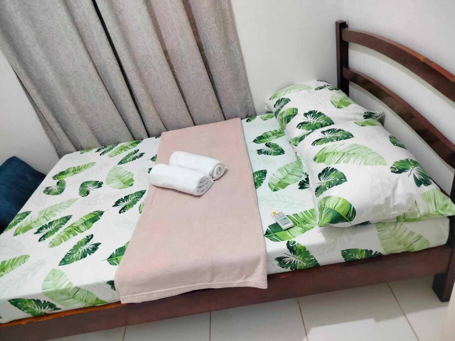 a bed with two rolled towels on top of it at comfy bungalow near ateneo de cebu in Mandaue City