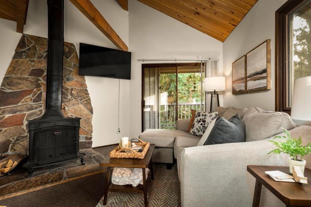 a living room with a couch and a fireplace at Cedar Creek Cabin in Whitefish