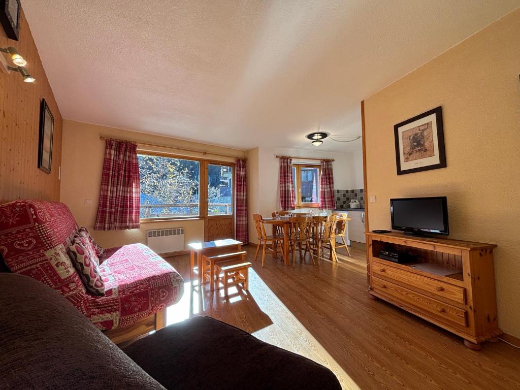 a living room with a couch and a tv at Résidence Atrey Clés Blanches in La Tania