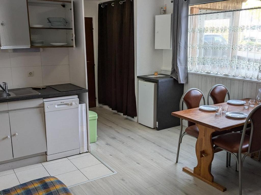 - une cuisine avec une table, une table et des chaises dans l'établissement Charmant studio 19m² pour 4 pers., accès direct pistes, proche commerces et activités, Orcières - FR-1-262-81, à Forest des Baniols