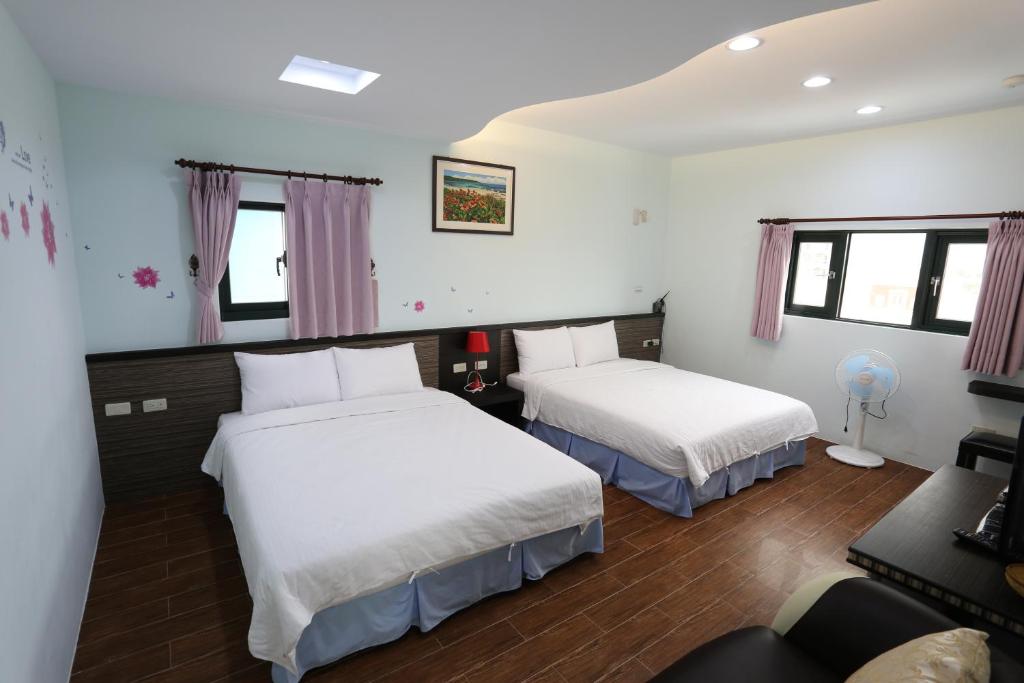 a bedroom with two beds and a couch at See Your Dreams B&amp;B in Magong