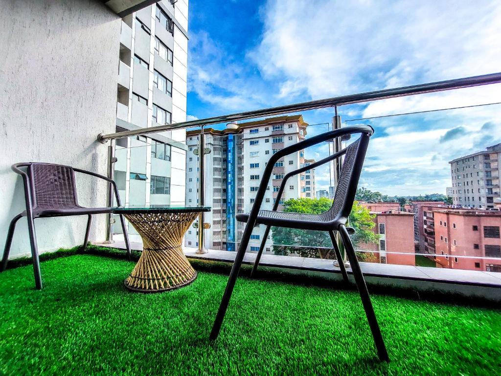 a balcony with a table and chairs on the grass at Carolina Homes - Kilimani in Nairobi