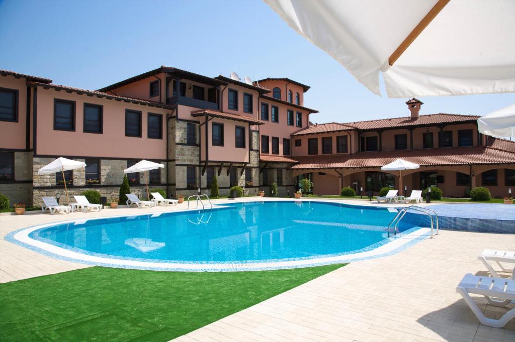 a swimming pool in front of a building at Hotel Domaine Peshtera in Peshtera