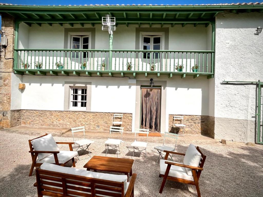 eine Terrasse mit Stühlen und Tischen sowie einen Balkon in der Unterkunft Casona a 1km de la playa de Gerra in La Revilla
