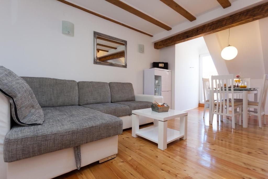 ein Wohnzimmer mit einem Sofa und einem Tisch in der Unterkunft Apartment Albidus A31 in Dubrovnik