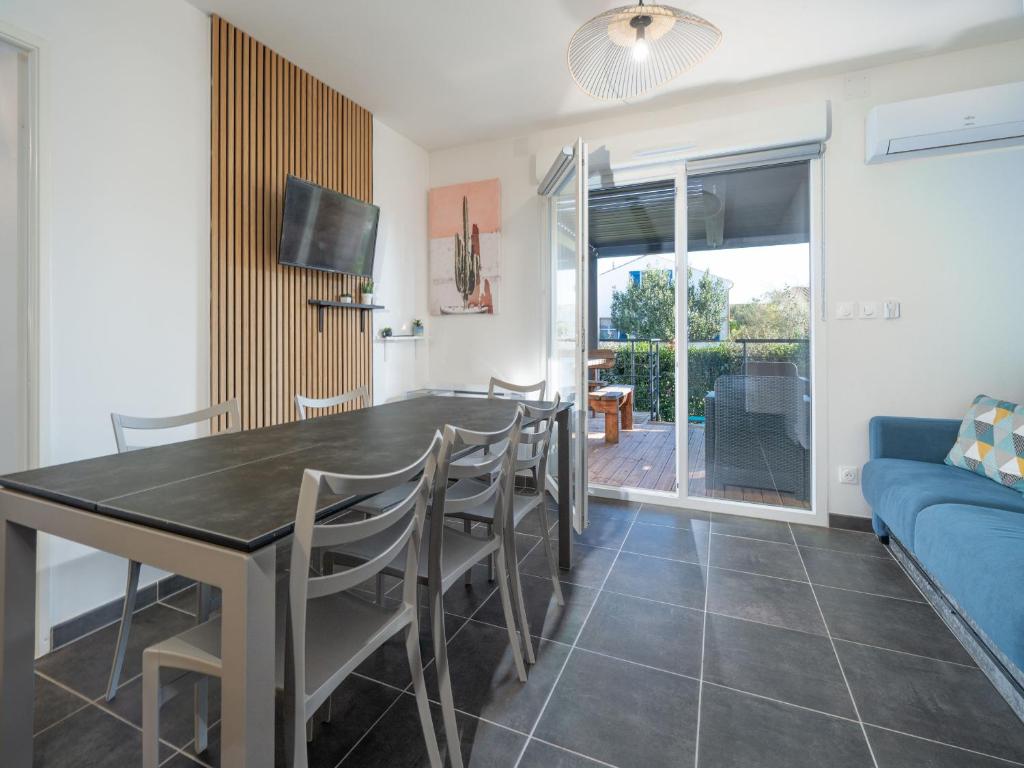 une salle à manger avec une table, des chaises et un canapé dans l'établissement La Dune 29 - VILLA 4P9, à Valras-Plage