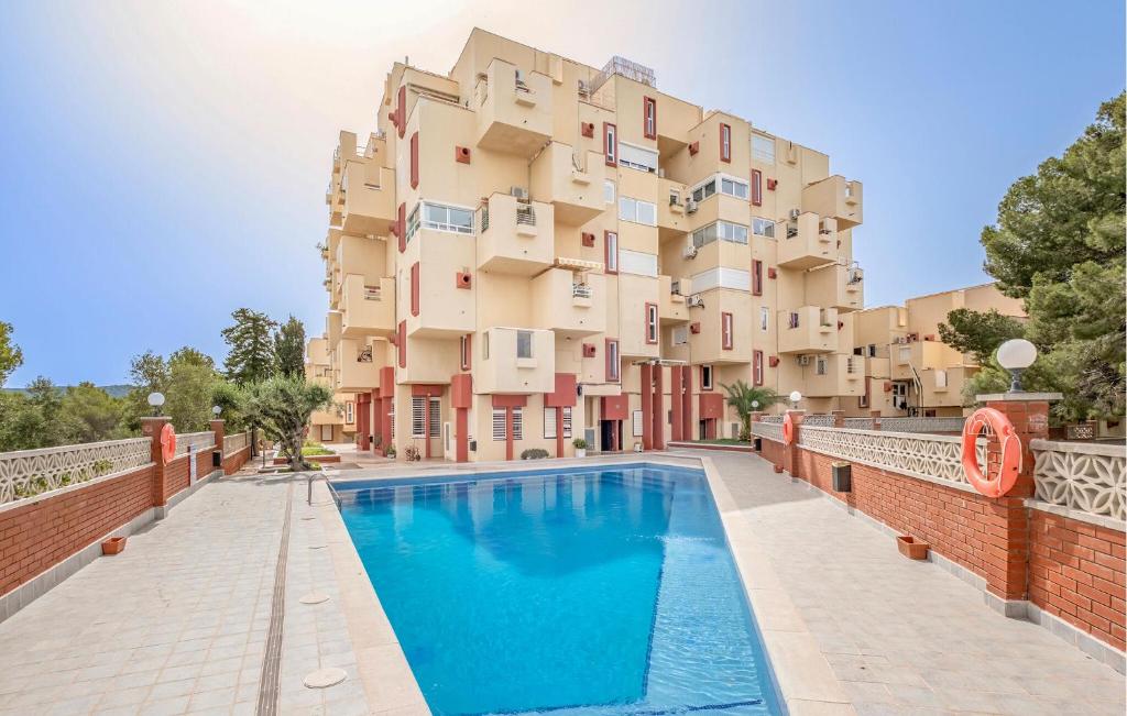 un apartamento con piscina frente a un edificio en Amazing Apartment In Sant Pere De Ribes, en Sant Pere de Ribes