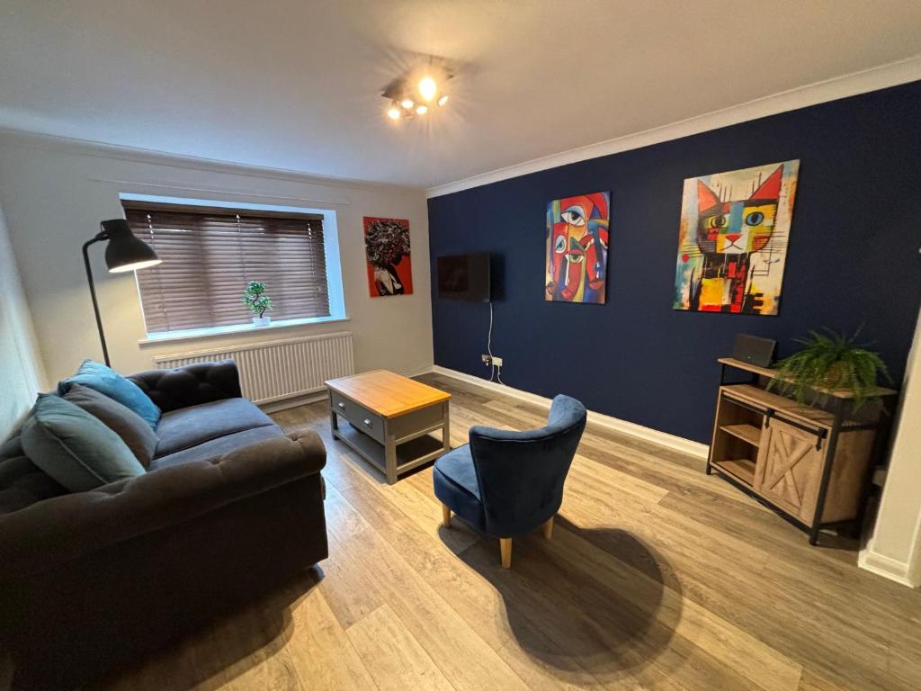 a living room with a couch and a table at Superb Central Flat, 3 mins to Station and Parking in Staines upon Thames