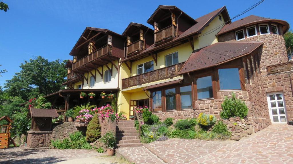 a large house with a stone wall at Prima Porta Vendeghaz in Balatonalmádi