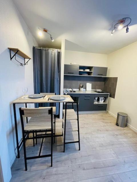 une cuisine avec une table et des chaises dans une pièce dans l'établissement Le Geneslay - Parking Privée, au Mans