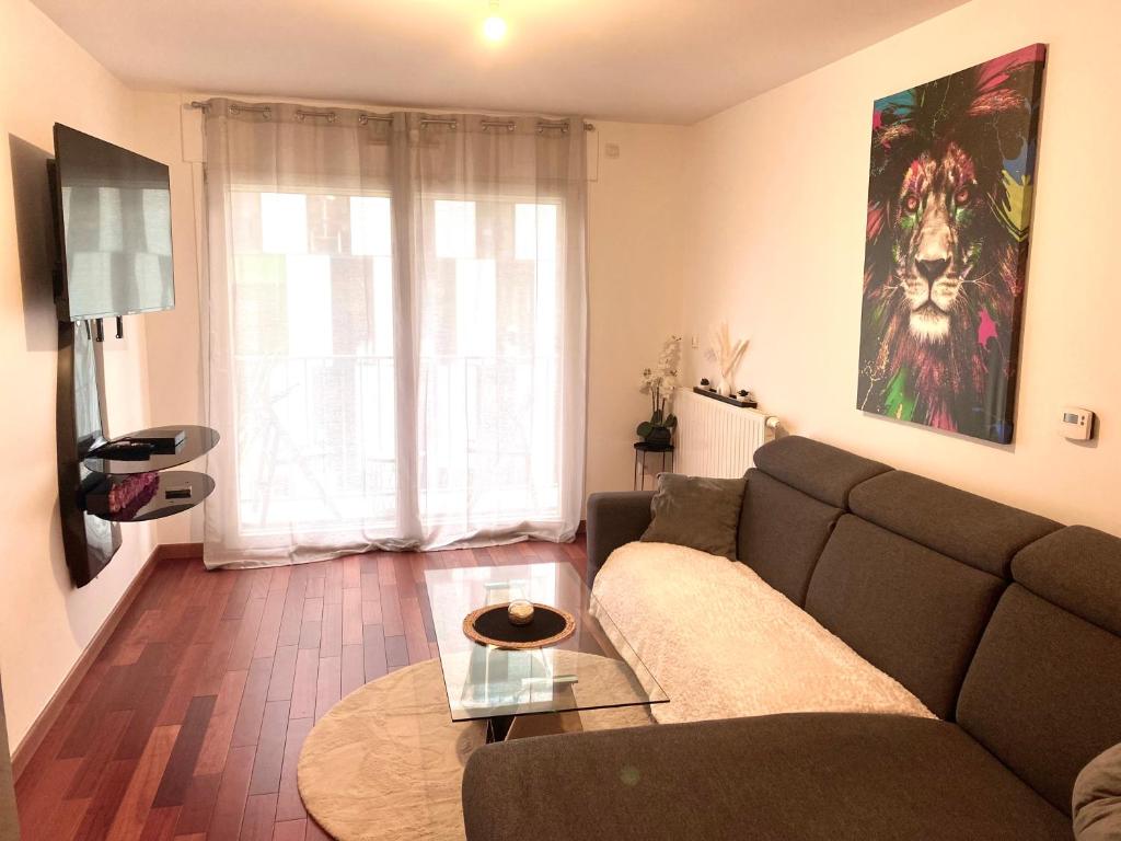 un salon avec un canapé et une table dans l'établissement Casa rosa parks Paris, à Paris