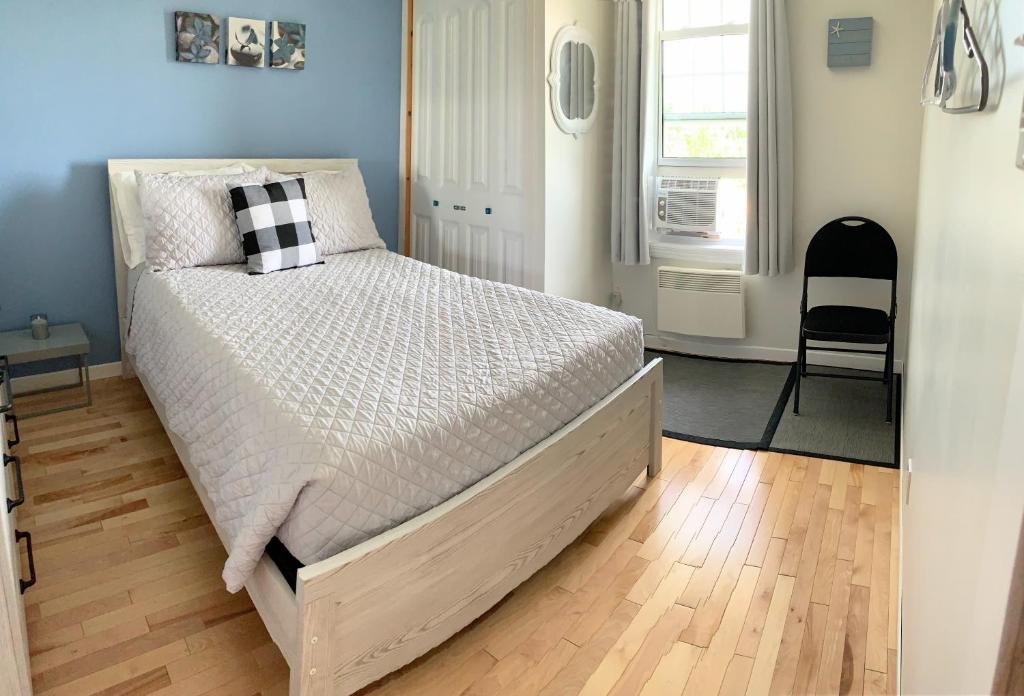 a bed in a bedroom with a wooden floor at Gîte Nycole in Perce