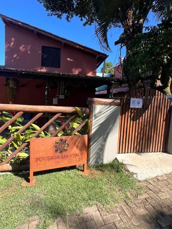 una señal frente a una casa con una valla en Pousada Mandala em frente a Praia da Concha, en Itacaré