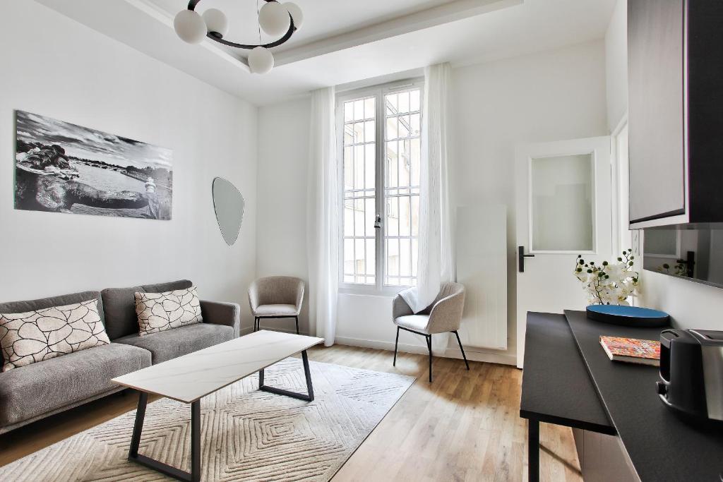 een woonkamer met een bank en een tafel bij Marais Elegence Suites - Two bedrooms in Parijs