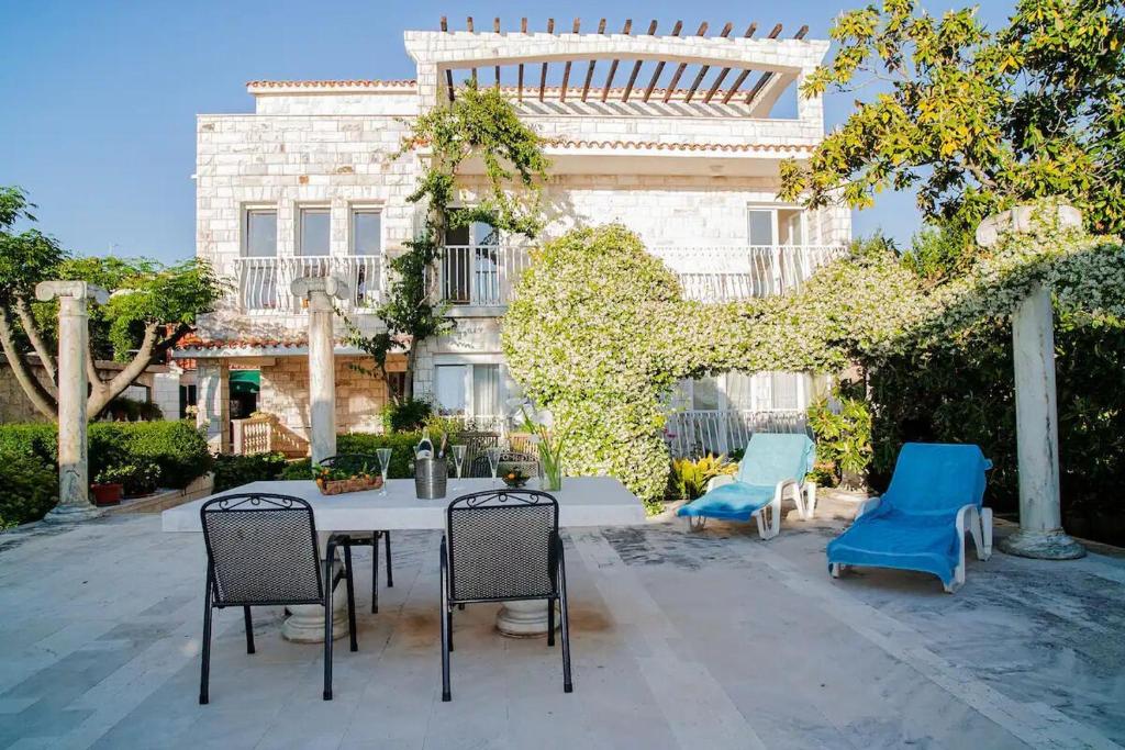 a patio with chairs and a table in front of a building at House Villa Oaza in Rogoznica